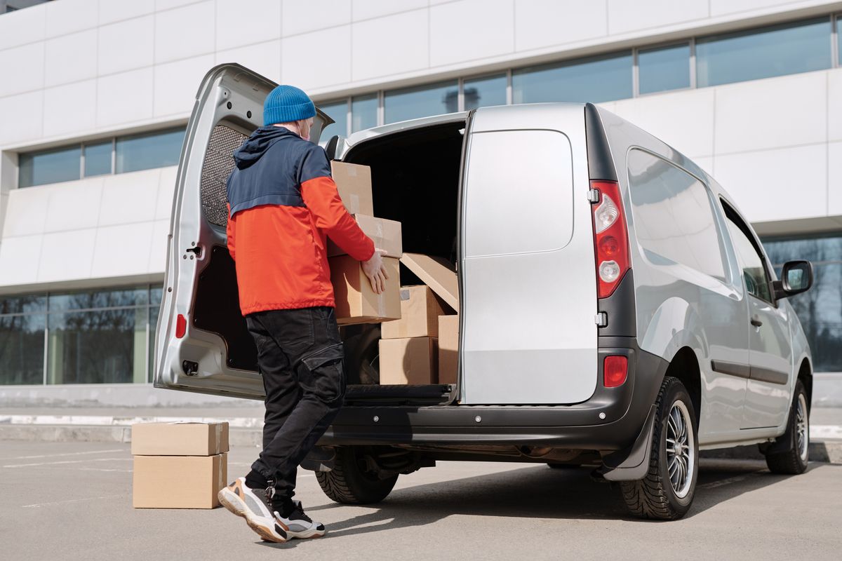 Un homme charge des cartons dans une camionnette.