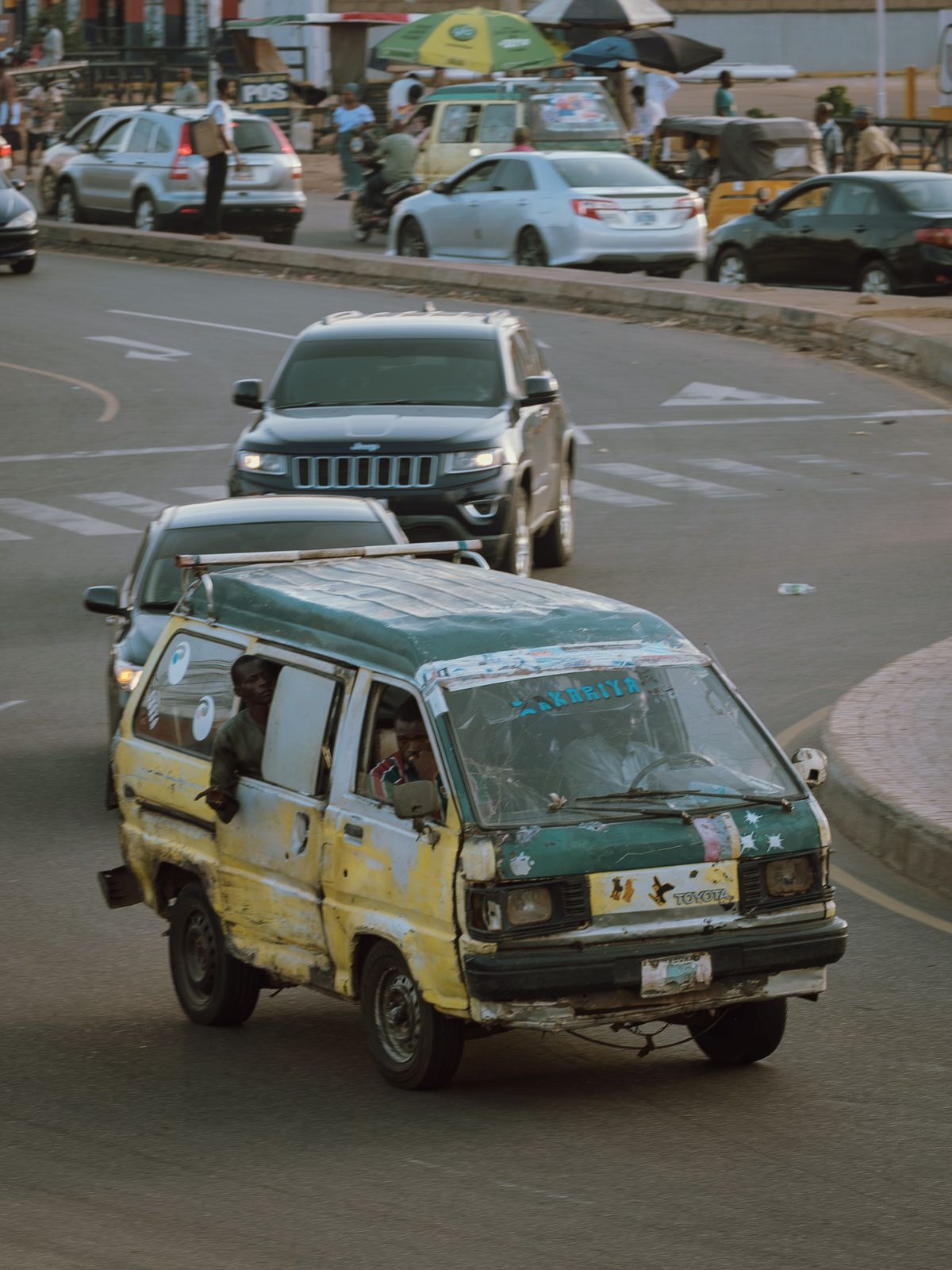 Ancienne camionnette circulant dans une rue en zone urbaine.
